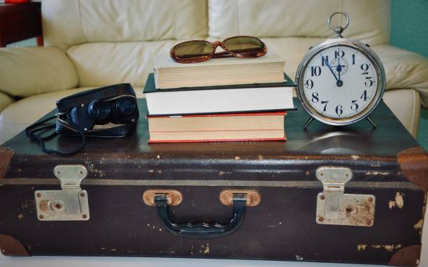 istock Retro suitcase with books, sunglasses, alarm clock and binocular 1222554218