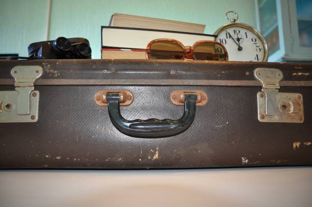 istock Antique brown suitcase with sunglasses, clock, books and binocular 1222554246