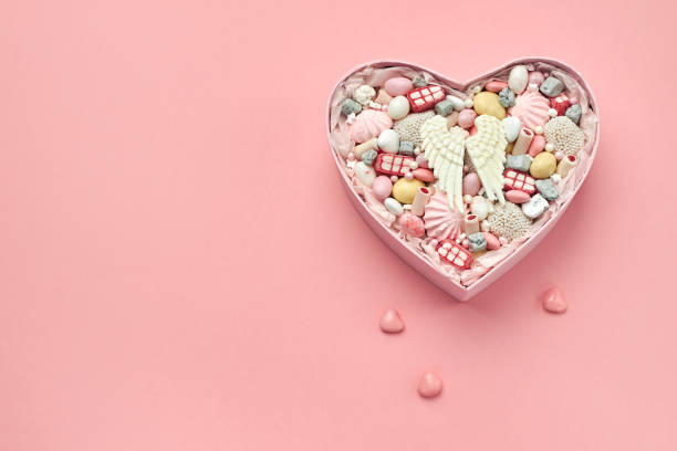 istock Heart shaped box filled with different sweets and handmade candies on a pink background, copy space 1222556849