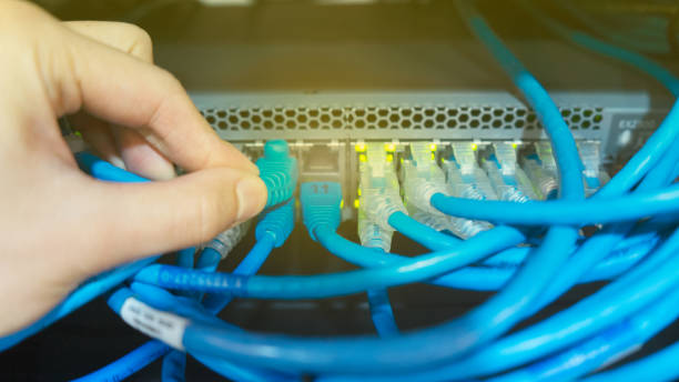 istock Plug LAN cable or RJ45 into network switch on data center technology a lot of server storage power cable and switch use connecting internet and store data. 1222556880