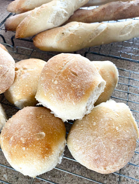 istock Freshly baked white rolls and French sticks on a cooling rack 1222560503