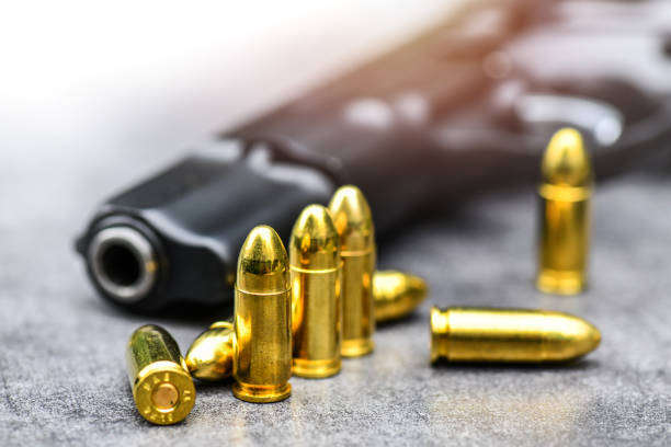 istock Gun with ammunition on stone background. 1222560817