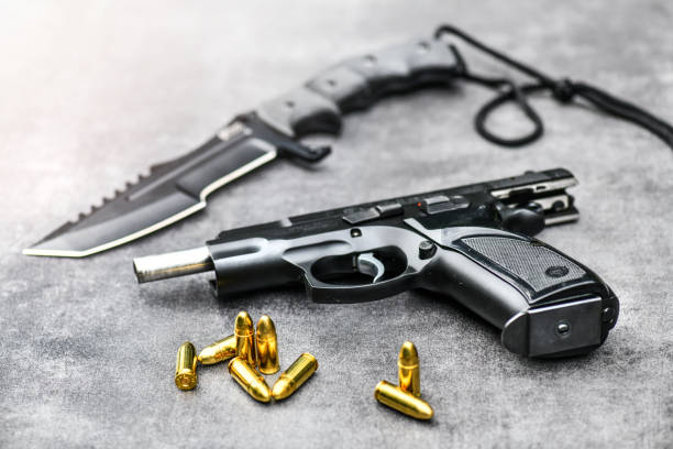 istock Gun with ammunition on stone background. 1222560819