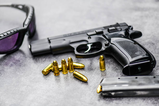 istock Gun with ammunition on stone background. 1222560820
