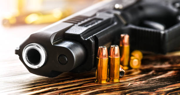 istock Gun with ammunition and money on stone background. 1222561071