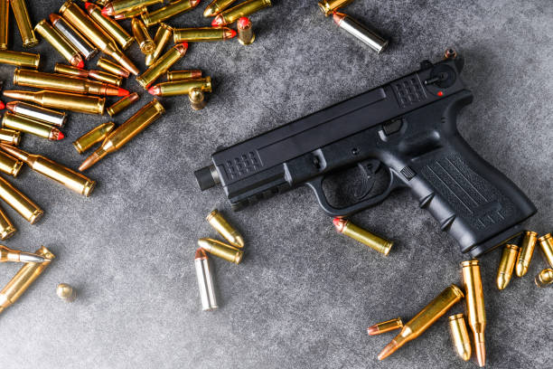 istock Gun with ammunition and money on stone background. 1222561093