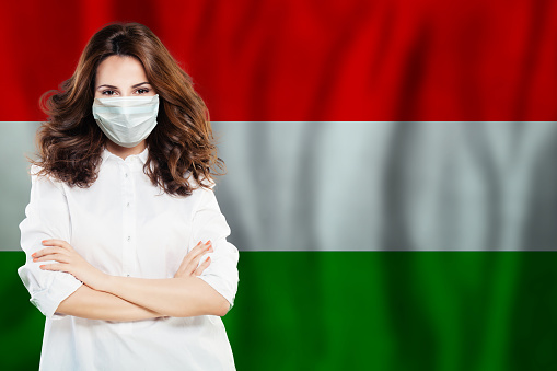 Nurse with face mask against national flag Hungary. Flu epidemic and virus protection concept