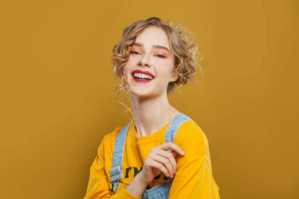 istock Happy smiling woman on bright yellow background 1222562035