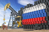 Oil production and extraction in Russia. Oil pump jack and oil barrels with Russia flag.