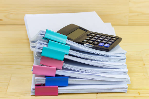 istock pile of papers with Calculator at work office for business on the table, concept document in work office 1222563992