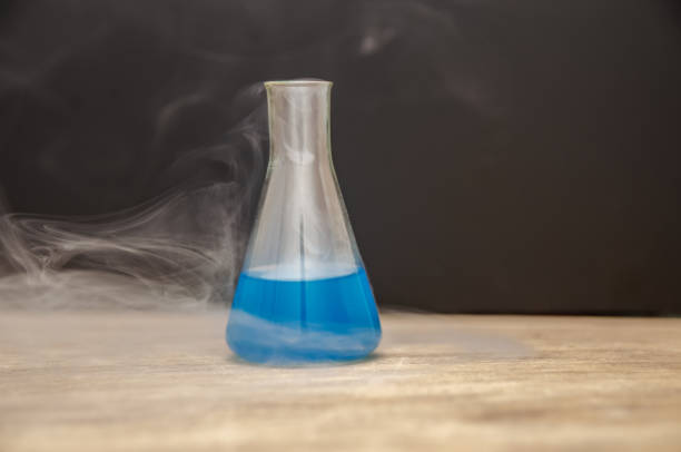 istock flask with blue liquid in smoke over black background. chemical analysis 1222572153