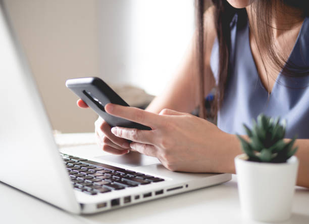 istock work from home concept with woman working on Smart Phone and laptop computer. 1222572670