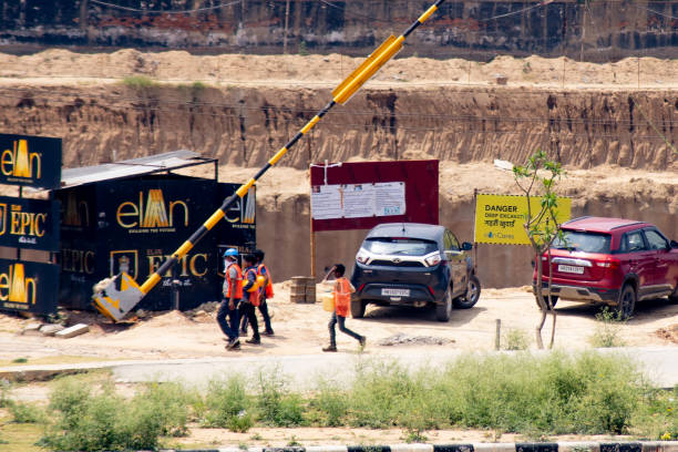 trabalhadores da construção civil retornando a um projeto de desenvolvimento imobiliário à medida que o setor imobiliário aquece após o bloqueio induzido pelo covid19 - bangalore india business building exterior - fotografias e filmes do acervo