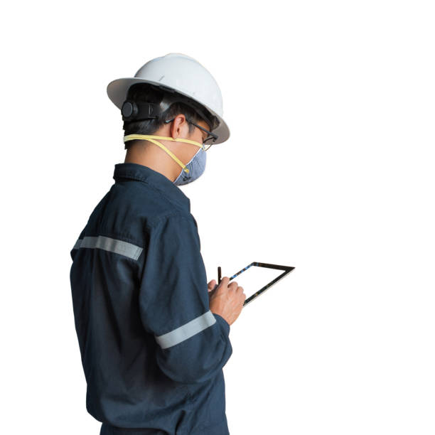 Protection against contagious disease, coronavirus. Asian Engineer Man or worker wearing hygienic mask N95 to prevent infection,airborne respiratory illness as flu,2019-nCoV,using tablet isolated. stock photo