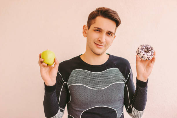 istock Difficult choice between healthy food for diet and junk sweet snack 1222572894