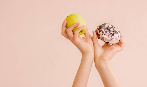 sweet struggle of fitness woman choosing healthy or unhealthy food - cake pick imagens e fotografias de stock