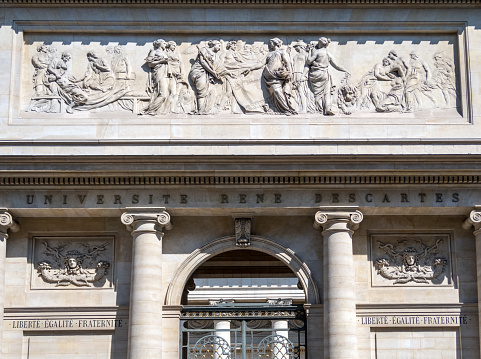 Classic antique old British bank sign engraved in stone or concrete above the door of the bank building, classic columns and architectural features. Focus on the word \