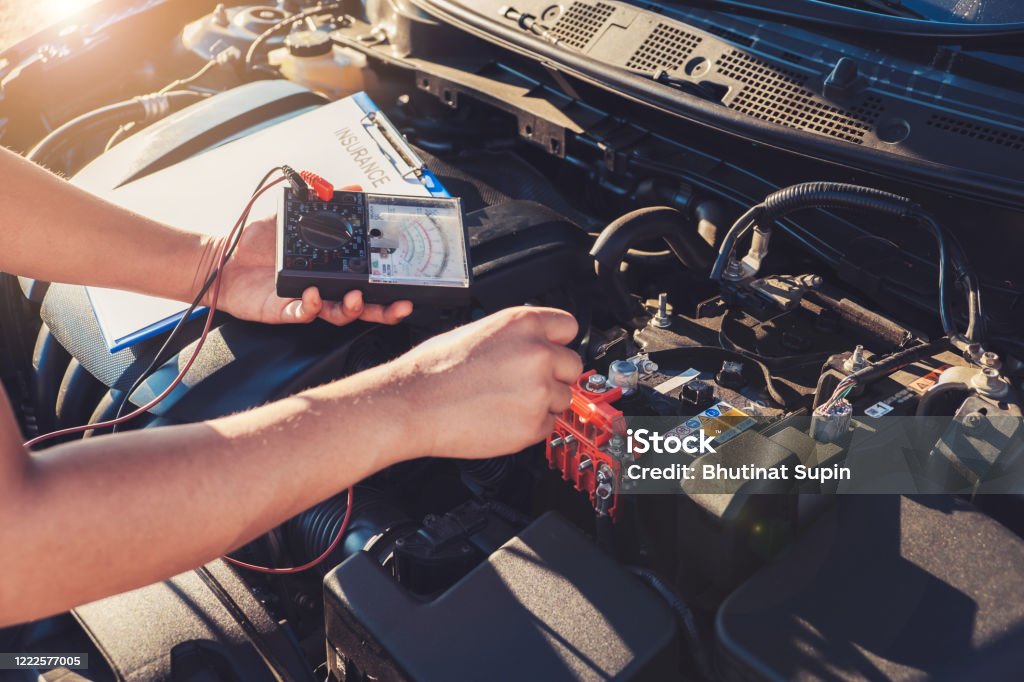 Auto mechanic is checking and test CCA battery with analyzer diagnostic tool. Auto mechanic is checking and test CCA battery with analyzer diagnostic tool, Car repair service concept. Adult Stock Photo