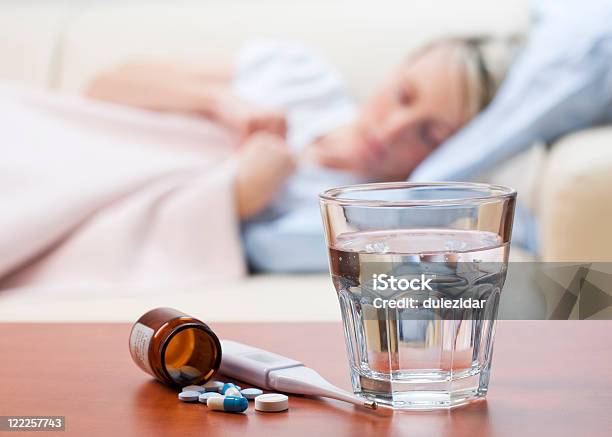 Medicine Thermometer And Water Left Out For A Sick Woman Stock Photo - Download Image Now