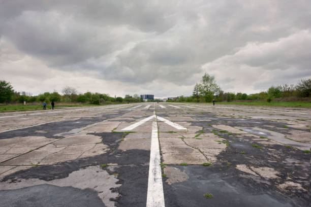 The site of an abandoned airport runway on a grey cloudy day.  This airfield in Poland was established by Austria-Hungary in 1912 and is one of the oldest in the world.