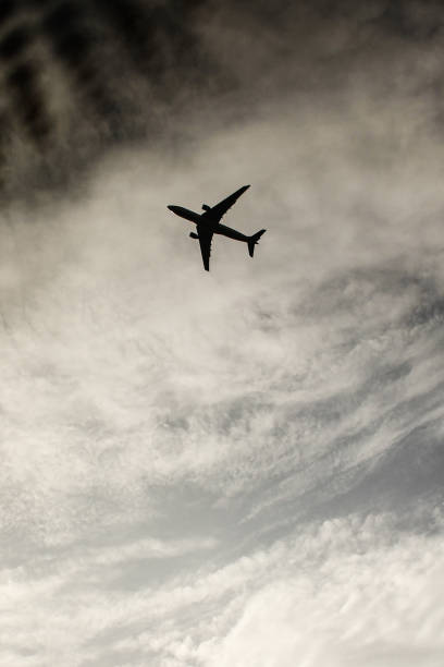 istock The plane in the cloudy sky, view from a window if a car, down shot. 1222578599
