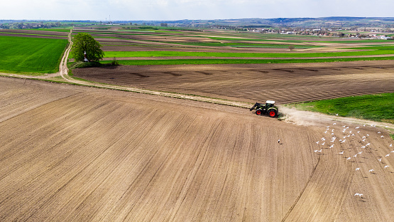 Tracktor Working in Fields at Countryside Farm. Aerial Drone View.