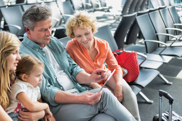 istock Mature man using digital tablet while his wife and daughter looking in airport 1222581242