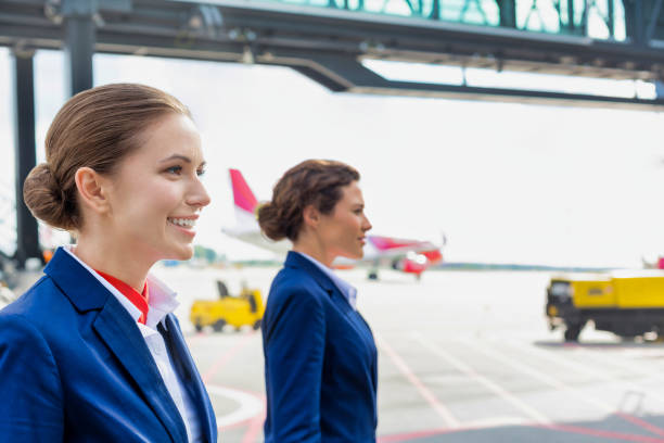 空港で飛行機に対して歩く自信に満ちた客室乗務員の写真 - cabin crew pilot airport walking ストックフォトと画像