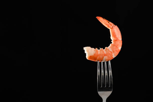 istock Closeup shrimp on fork isolated copy space on black background. 1222583286