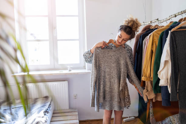 young woman choosing clothes - calca imagens e fotografias de stock