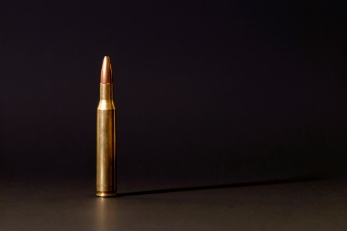A 7.62 mm caliber bullet isolated on black