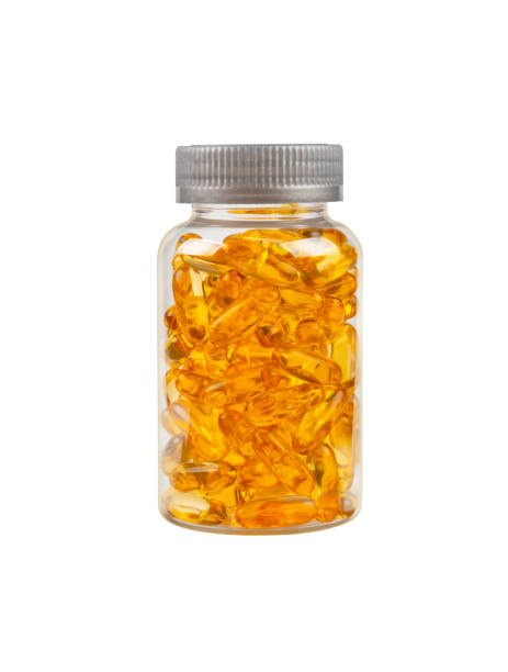 Bottle of Omega 3 oil gel cap pills on white Close up one bottle of yellow Omega 3 vitamins and essential fish oils gel cap pills isolated on white background, low angle side view low quality of life stock pictures, royalty-free photos & images