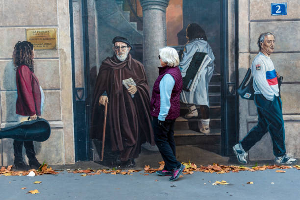 Lyon, France -- November 5, 2017.  A woman examines a life sized mural on a street in Lyon on an Autumn day.