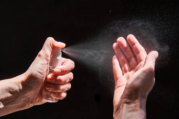 istock Hand spraying sanitizer over black background 1222591759