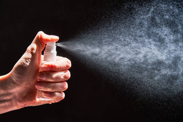 istock Human hand spraying sanitizer over black background 1222591784