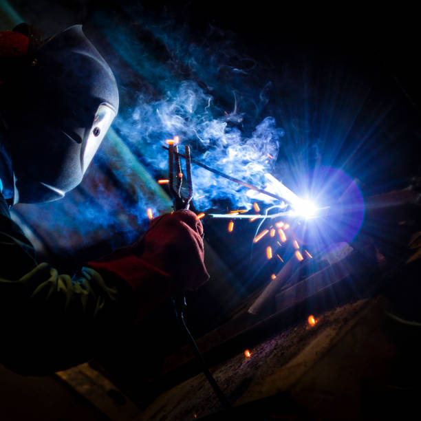 istock welder doing metal work at night, front and background blurred with bokeh effect 1222592584