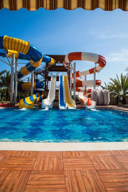 Colorful waterpark tubes and pool in tropical aquapark