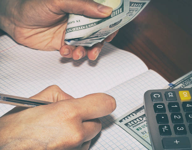 istock Budgeting planning. Calculating finances on a calculator. Writing in a notebook 1222594589