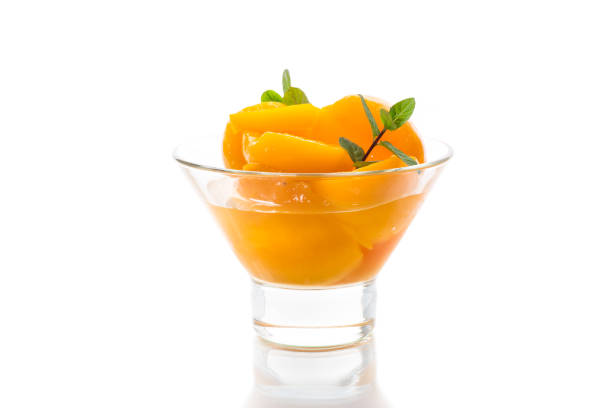 sweet canned apricots in syrup in a glass bowl stock photo