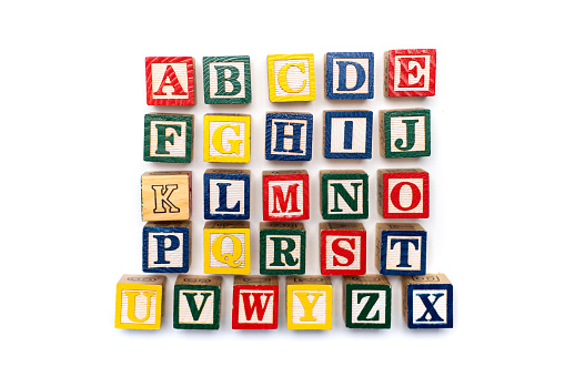 Alphabet characters ordered and written with wooden letters, education abstract background top view