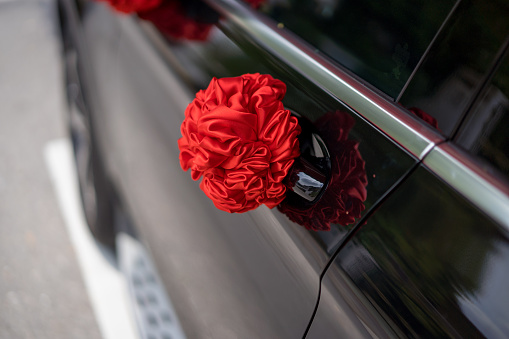 Red ribbon decoration on wedding car