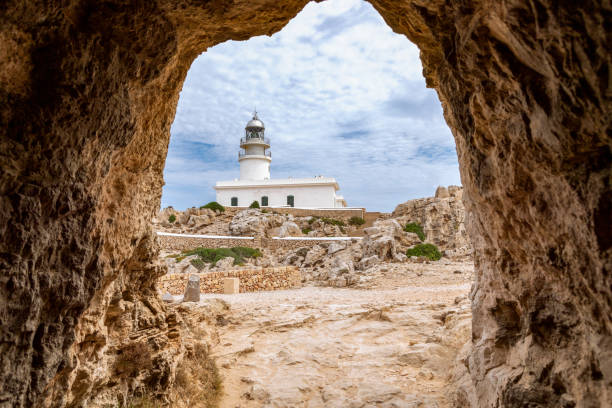 View from Cavalleria tunnel to the lighthouse (Faro de Cavalleria). Menorca, Balearic islands, Spain View from Cavalleria tunnel to the lighthouse (Faro de Cavalleria). Menorca, Balearic islands, Spain minorca photos stock pictures, royalty-free photos & images