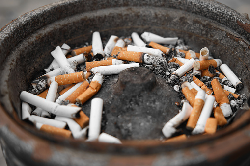 Burning cigarette with ashtray , black background
