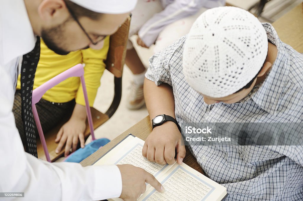 Actividades en materia de enseñanza en montaje tipo aula, profesor de religión musulmana mostrando Corán para niños - Foto de stock de Corán libre de derechos