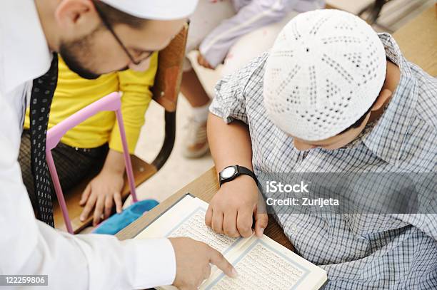 Actividades En Materia De Enseñanza En Montaje Tipo Aula Profesor De Religión Musulmana Mostrando Corán Para Niños Foto de stock y más banco de imágenes de Corán