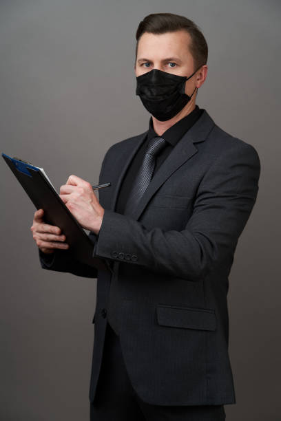 istock Businessman Holding a Clipboard document. Coronavirus pandemic prevention concept 1222600735