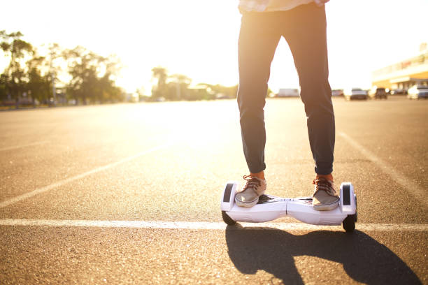 Young man riding on the Hoverboard in the park. Young man riding on the Hoverboard in the park. Close Up of Dual Wheel Self Balancing Electric Skateboard Smart hoverboard stock pictures, royalty-free photos & images