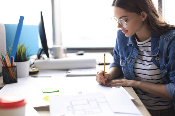 istock Concentrated young woman writing something down while working in the office. 1222603902