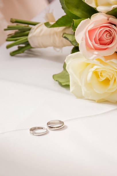 istock Wedding rings on a table with roses 1222603937