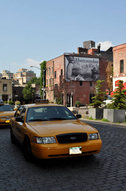 Abercrombie & Fitch outdoor advertising with a yellow taxi Meatpacking District in New York. Abercrombie & Fitch outdoor advertising in one of the building and a taxi stand in the foreground abercrombie fitch stock pictures, royalty-free photos & images